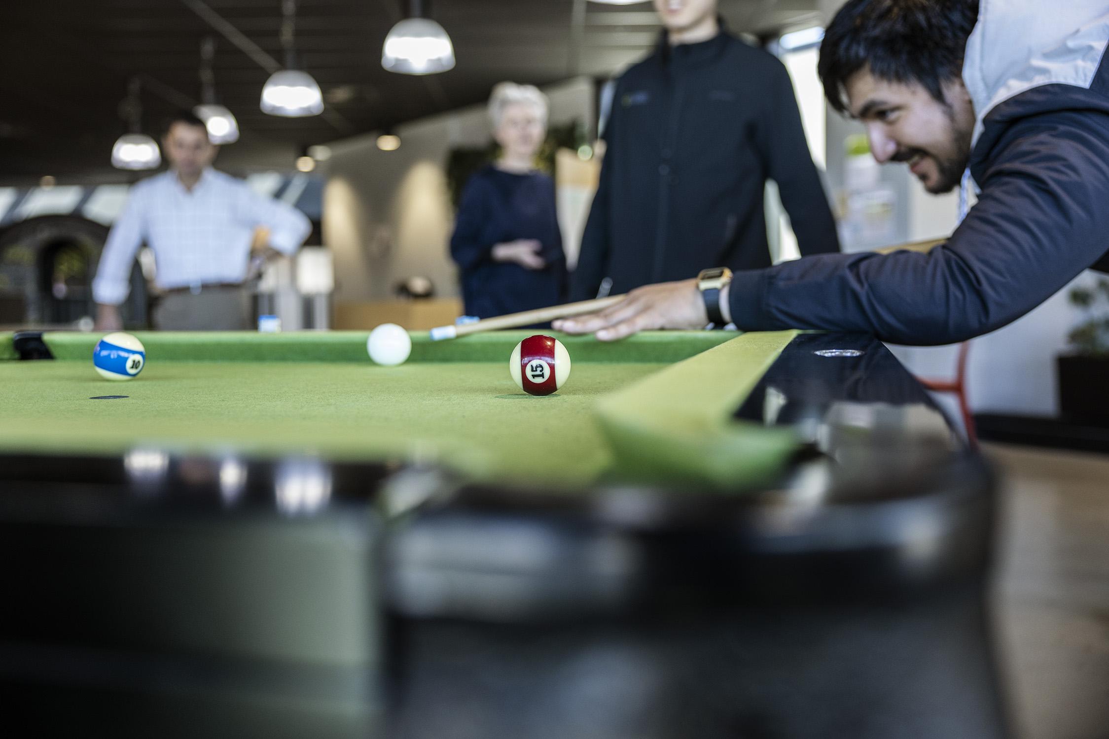 At the Harrison Grierson office, a man enjoys a game of pool.