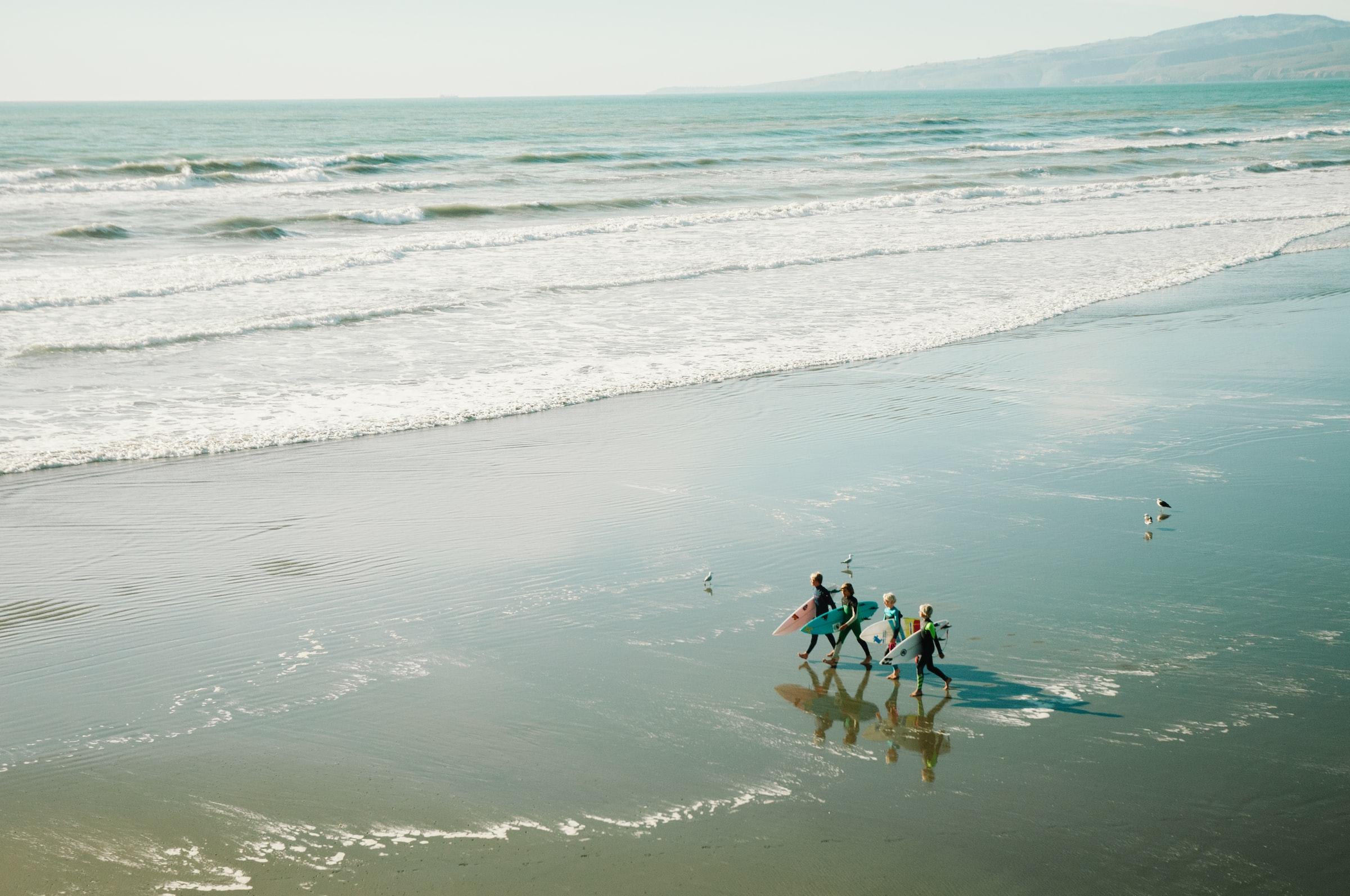 A group of individuals walking along the beach at New Brighton.