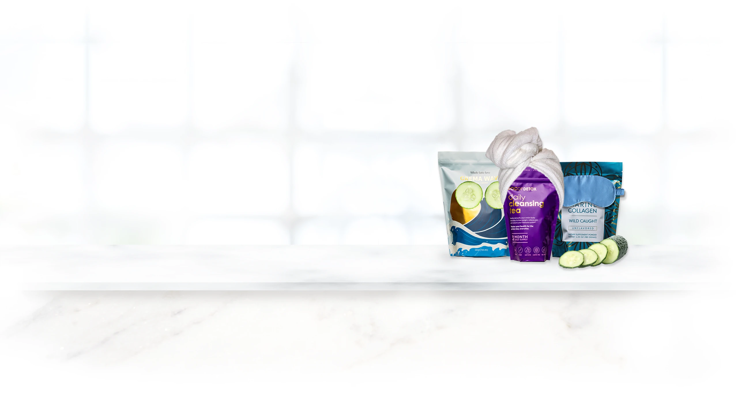 Skincare and detox products displayed with sliced cucumbers on a marble surface.
