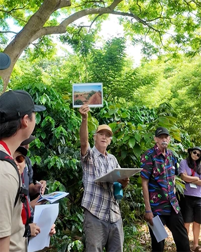 Farmer Gary at Kupa'a Farms in Hawaii holding up a photo of soil during a group tour.