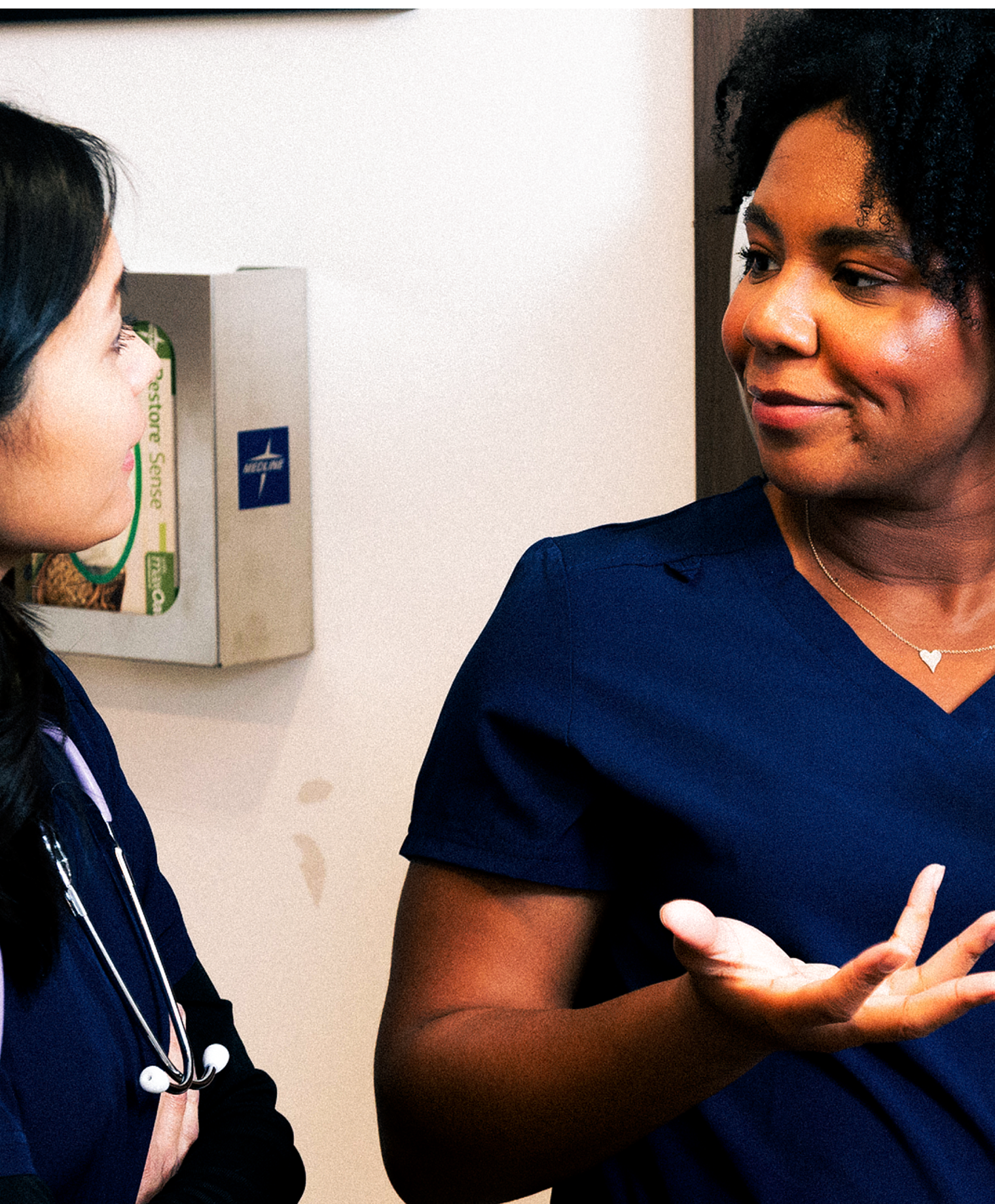Two nurses in a hospital discussing patient care.