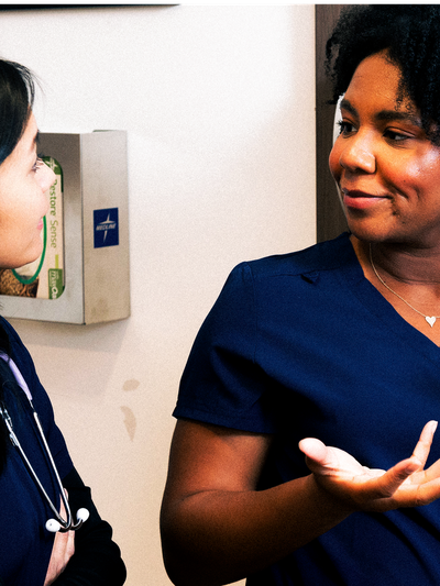 Two nurses in a hospital discussing patient care.