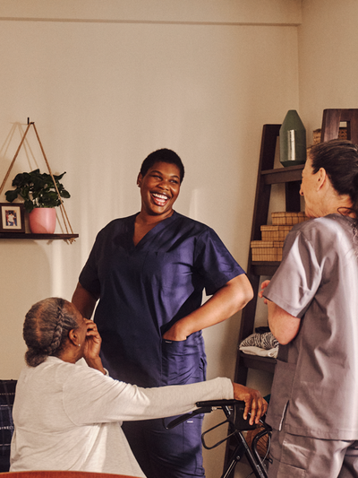 A resident and two independent professionals laughing together.