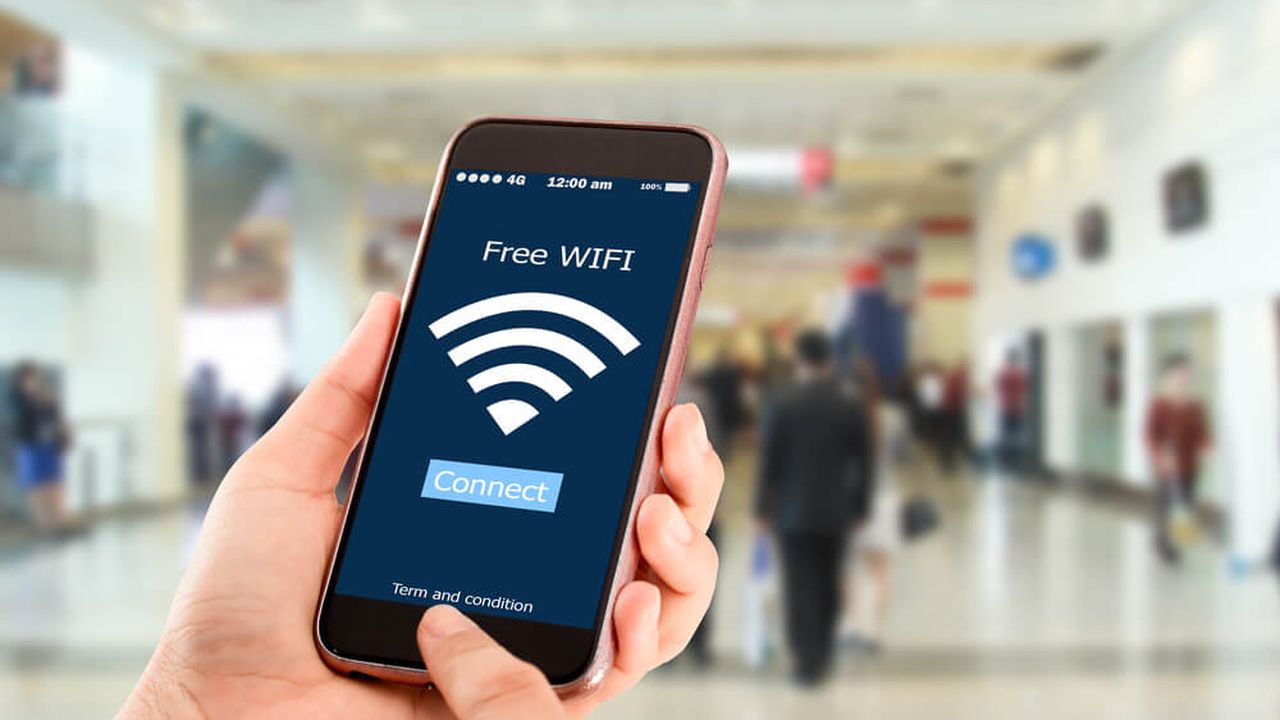 Photo of a hand holding a smartphone with 'Free WiFi' on the display
