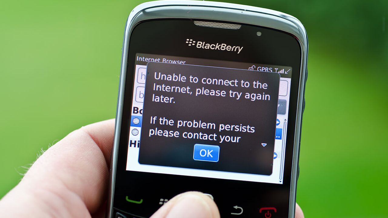 A blackberry phone with an error message popping up on the screen that says "unable to connect to the internet, please try again later"