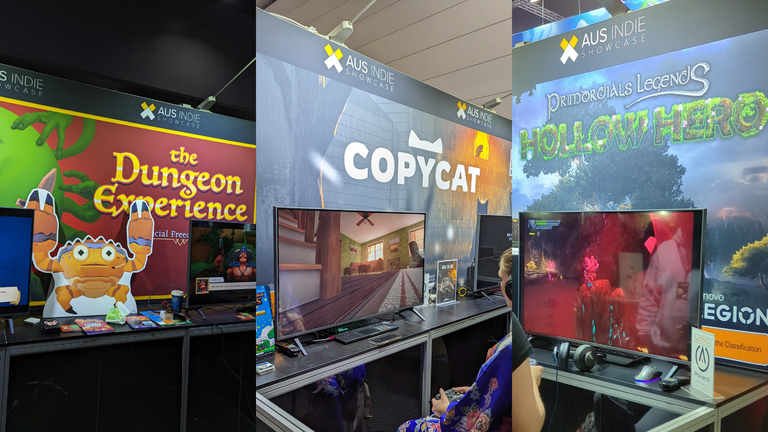 An image of three photos of three different game stands at a convention. The first is a photo of a game called "The Dungeon Experience" with a cutout of a character in the form of a crab, and two televisions showing the game either side. The second image is of the game "Copycat", with a TV showing the game underneath as well. Finally, the last game is "Primordials Legends: Hollow Hero" with a TV showing the game underneath. All games have "Aus Indie Showcase" written above them.