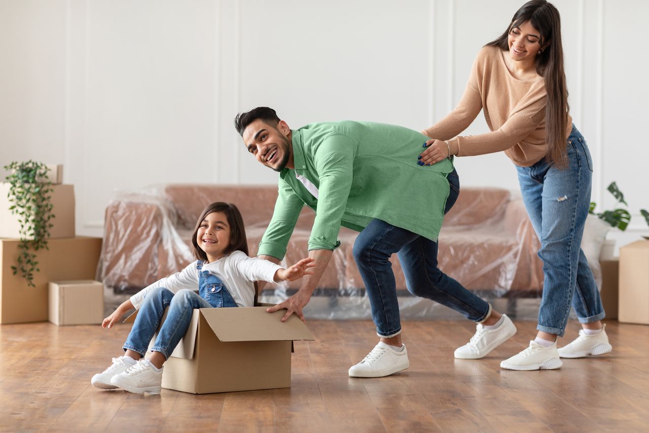 A family moving house and having fun playing with the empty boxes