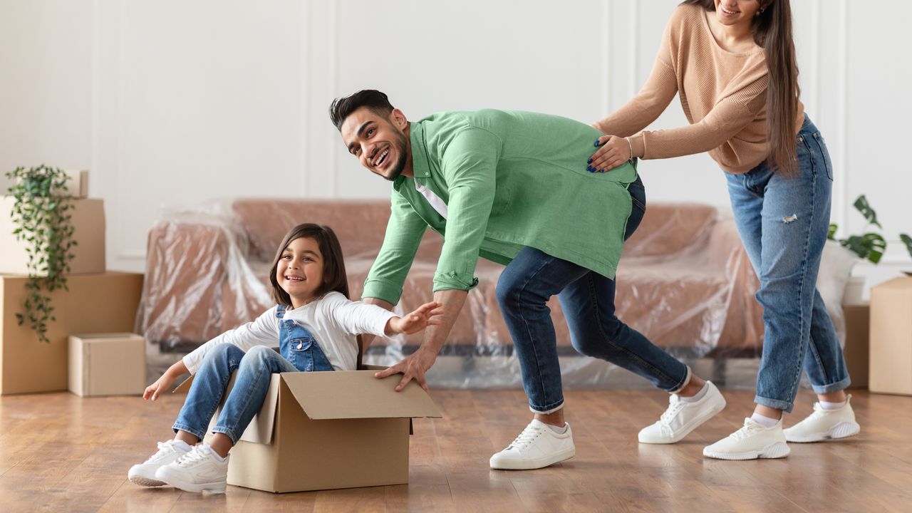 A family moving house and having fun playing with the empty boxes