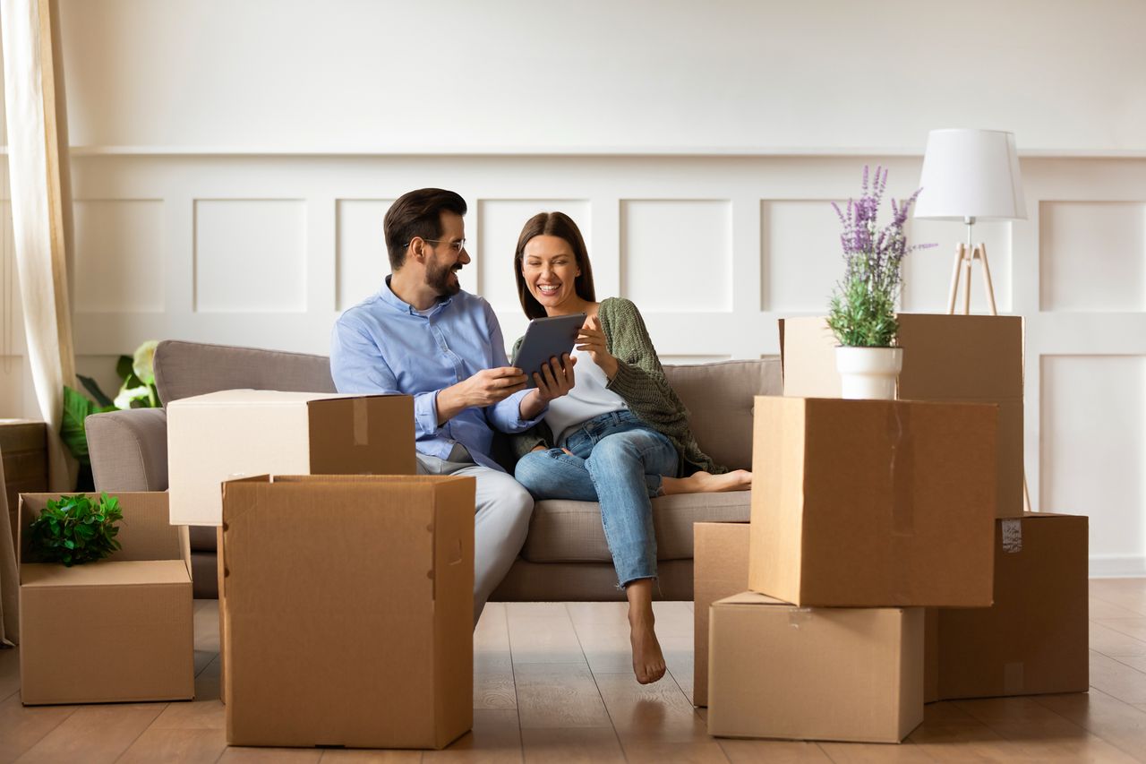 A couple moving house and sharing memories while they unpack photo frames