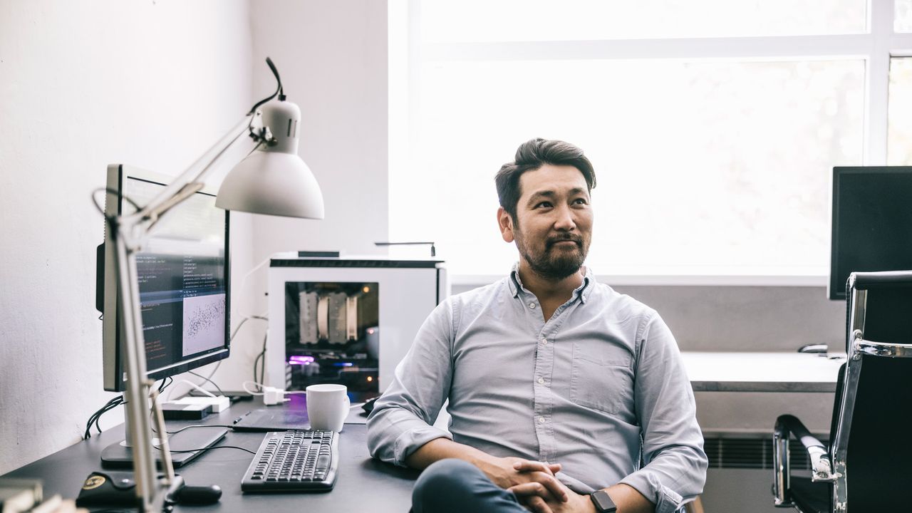 Photo of a person sitting at a computer workstation