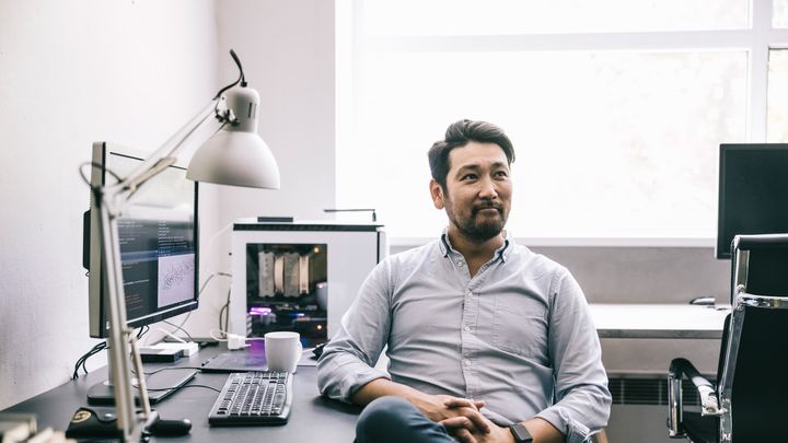Photo of a person sitting at a computer workstation