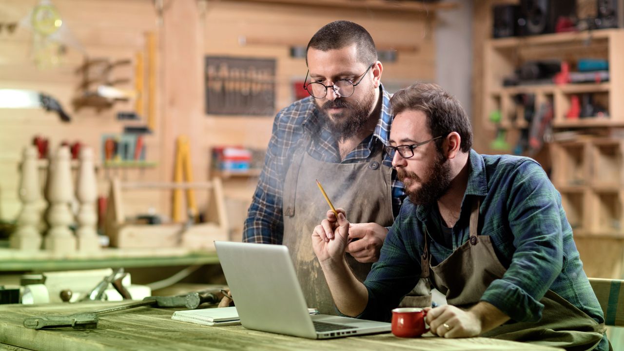 Two business owners in their creative studio looking at a laptop