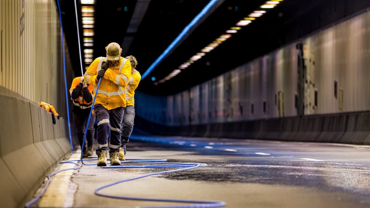 Aussie Broadband engineers laying cable in the Sydney Habour tunnel