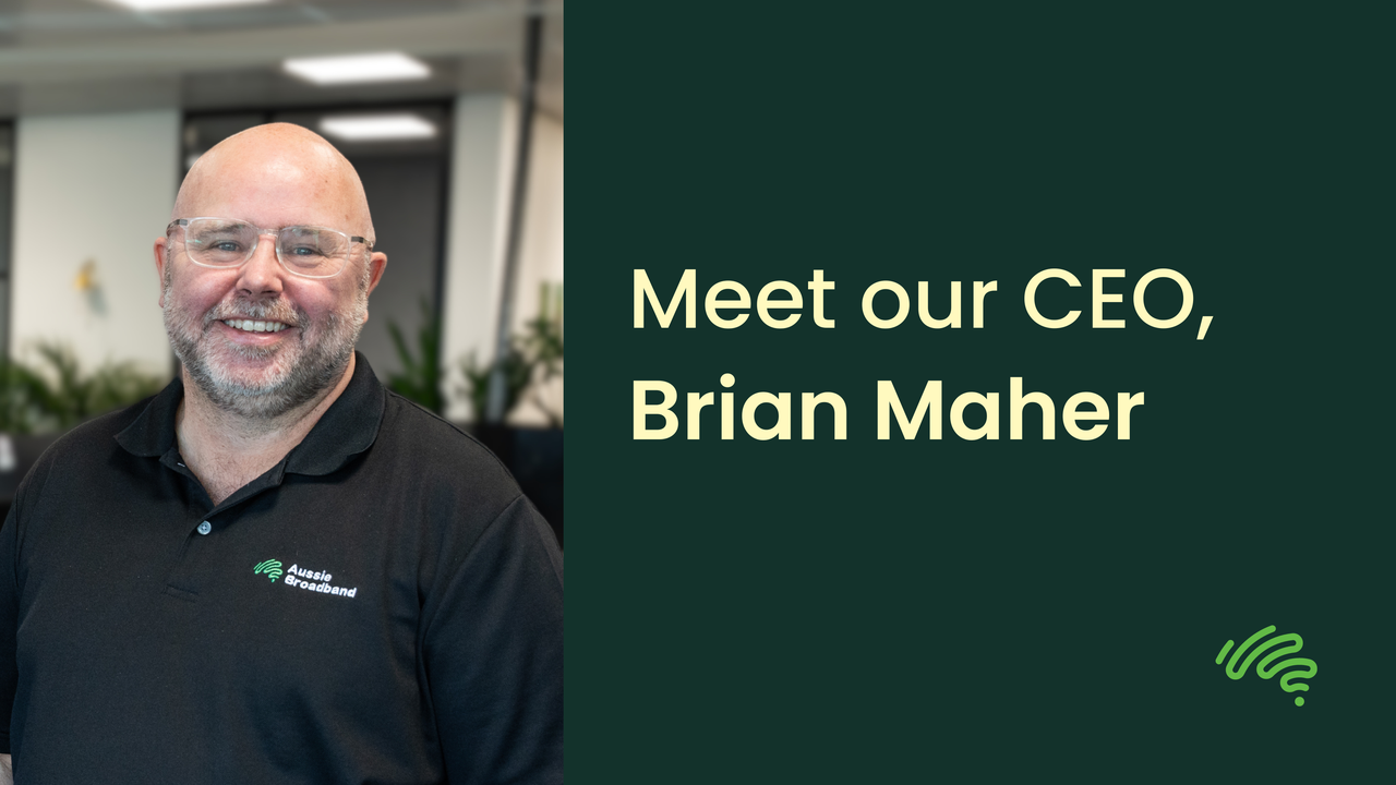 A graphic with a photo taking up the left third, and the right two-thirds being on a dark green background with yellow text and an Aussie Broadband logo in the bottom-right corner. The photo depicts CEO Brian Maher in a black polo smiling with an office environment behind him. The text on the right says "Meet our CEO, Brian Maher".