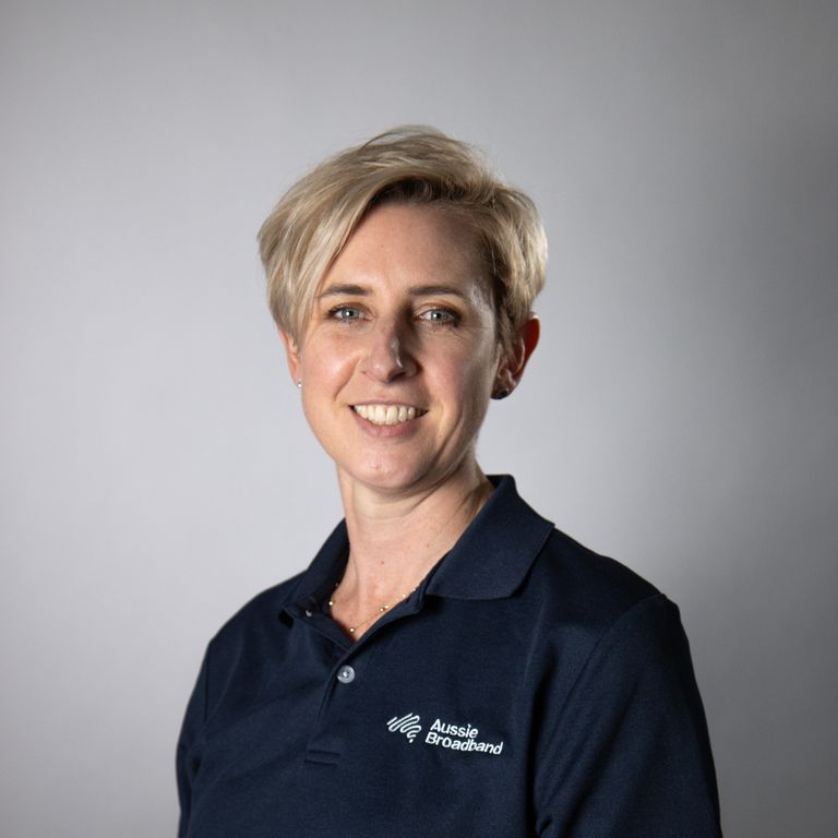 Anna Clive, in an Aussie Broadband polo shirt, smiles at the camera.