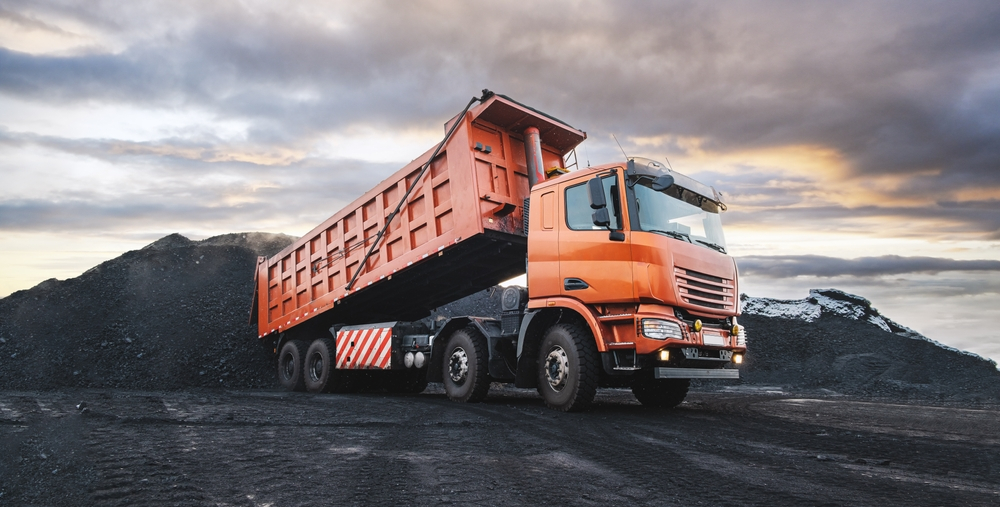 Dump Trucks Hauling the Weight of Progress Boom & Bucket
