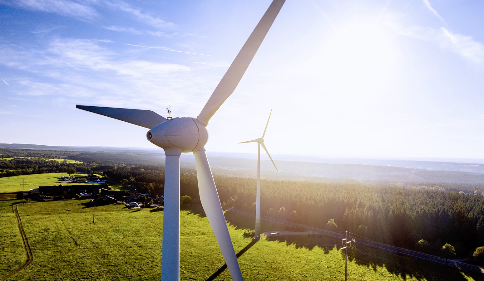 Two clean energy wind turbines in a field