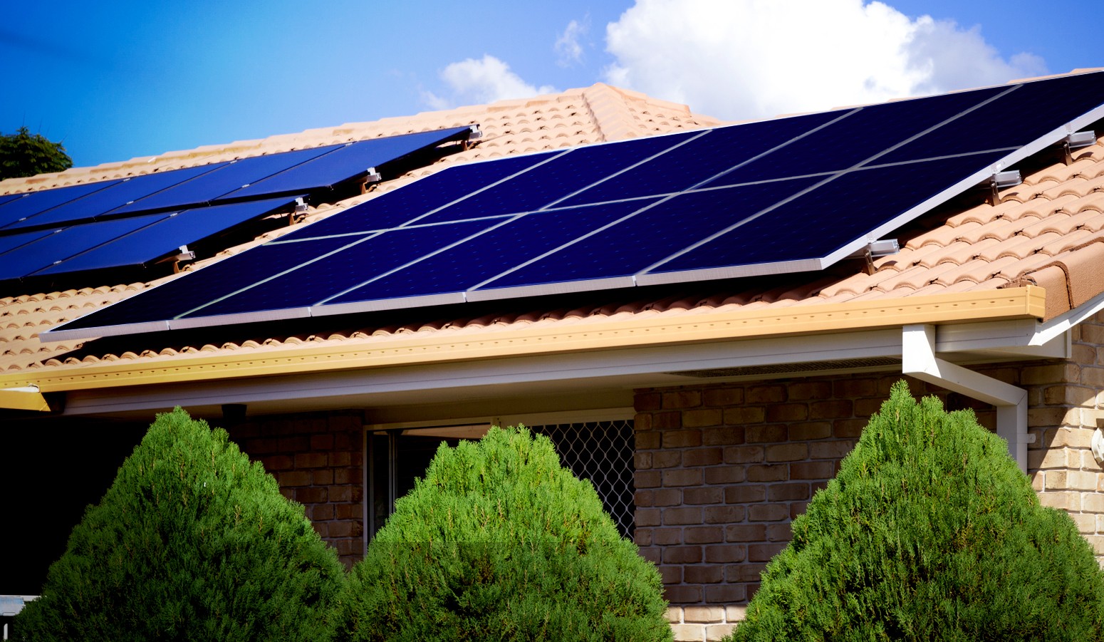 A home with a brown Spanish tile roof with solar panels on it