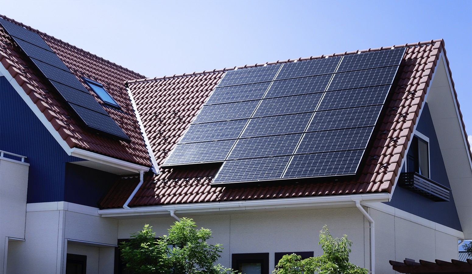A steep residential spanish roof with solar panels on top.
