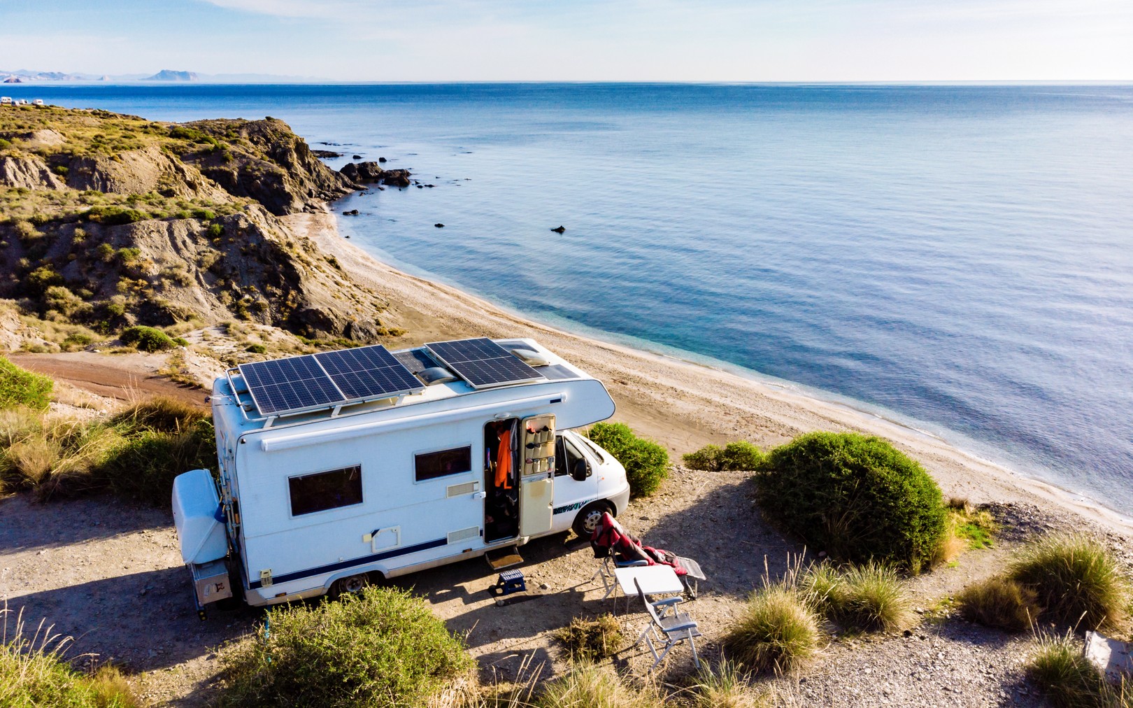 Solar panels on a camping truck by a coastline