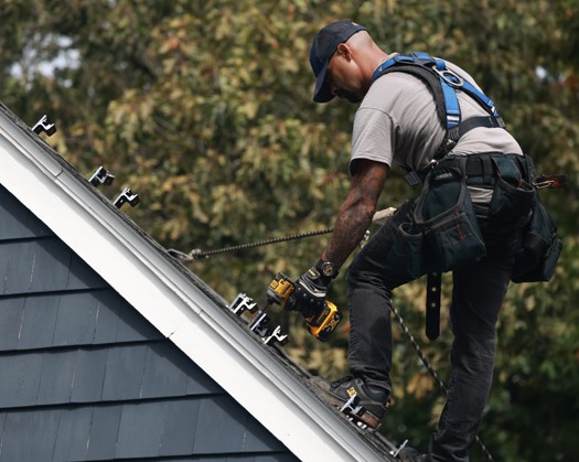 A technician installing solar panels on a roof