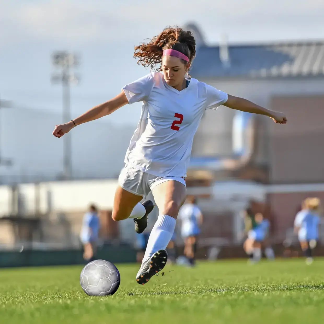 Youth soccer player kicks soccer ball on field