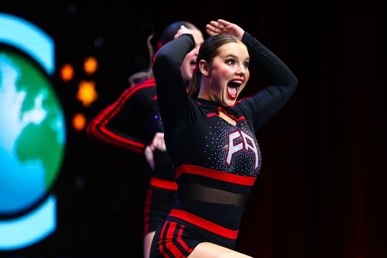 Cheerleader in uniform cheering at competition mid-cheer