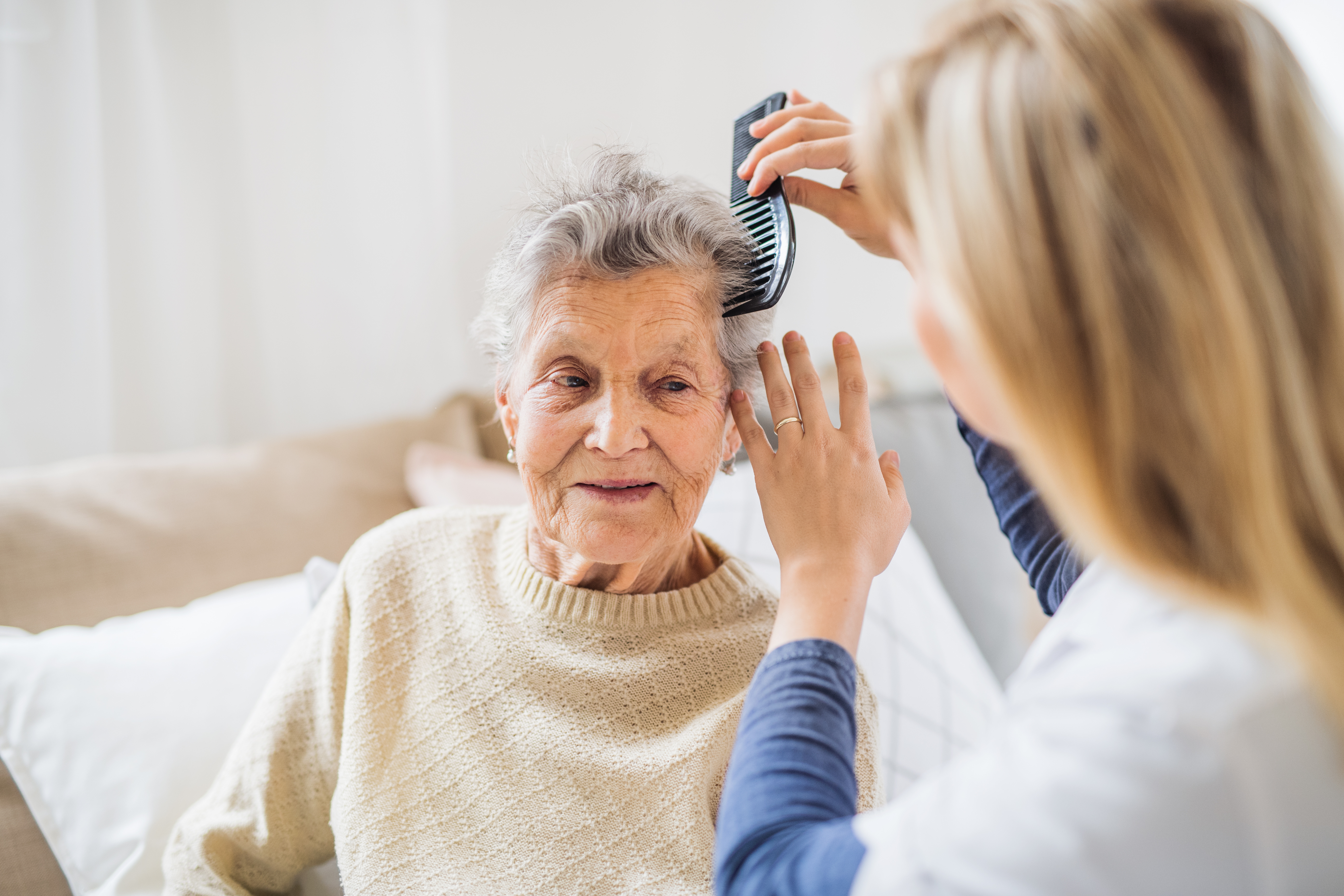 caregiver-brushing-older-adults-hair