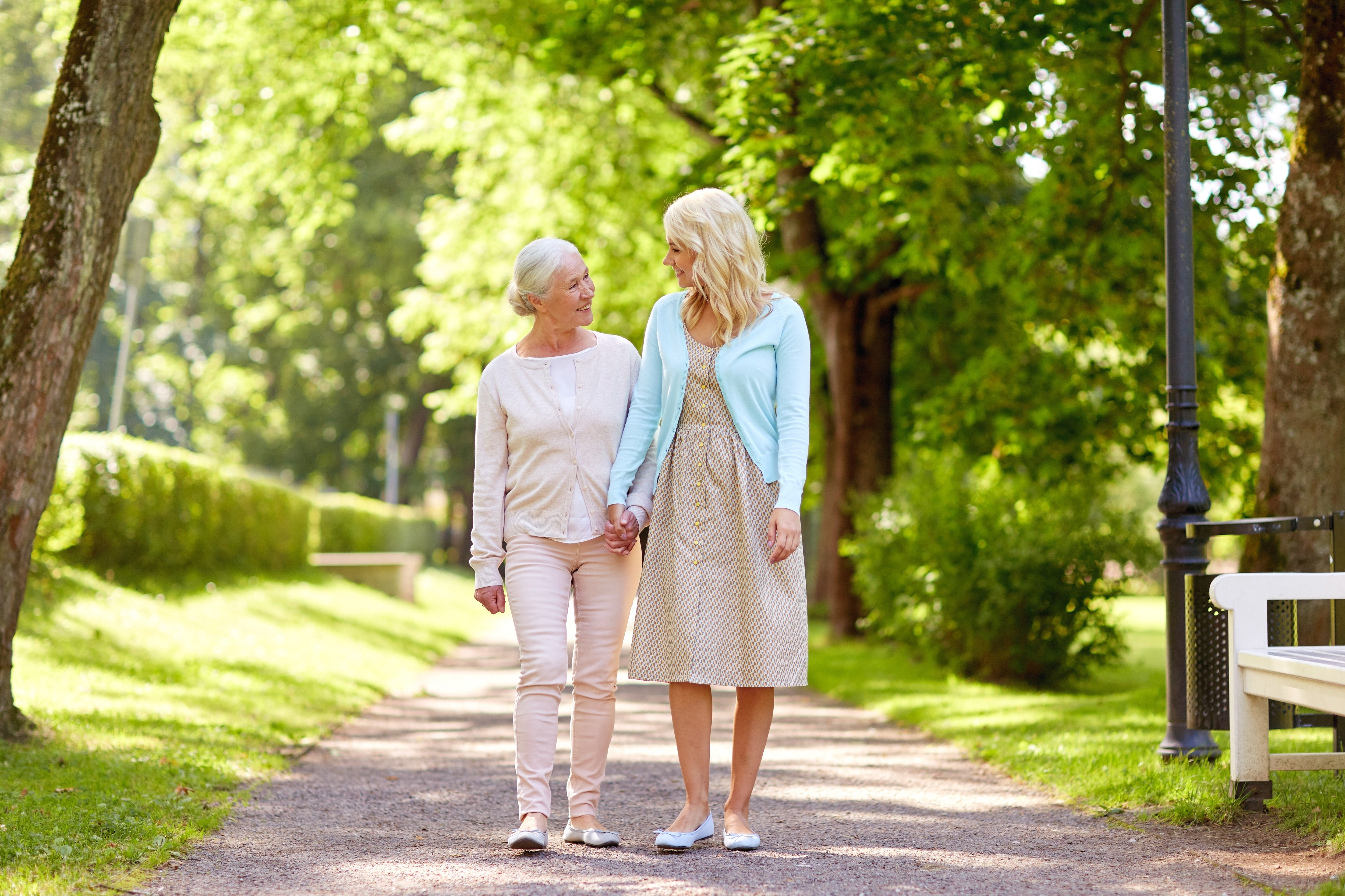 older-adult-woman-walking-with-adult-child-inside-park