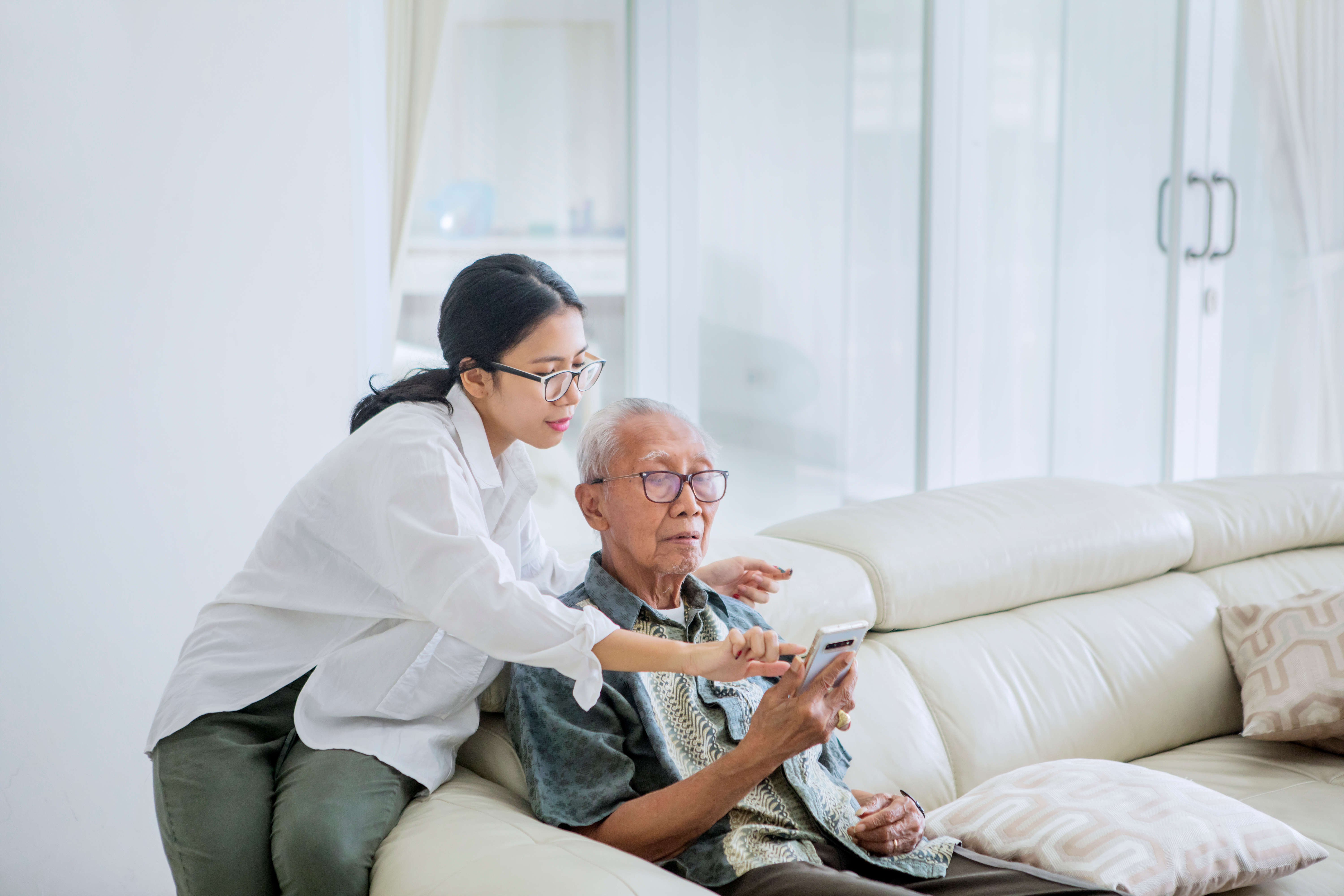 adult-child-showing-phone-to-older-adult-parent