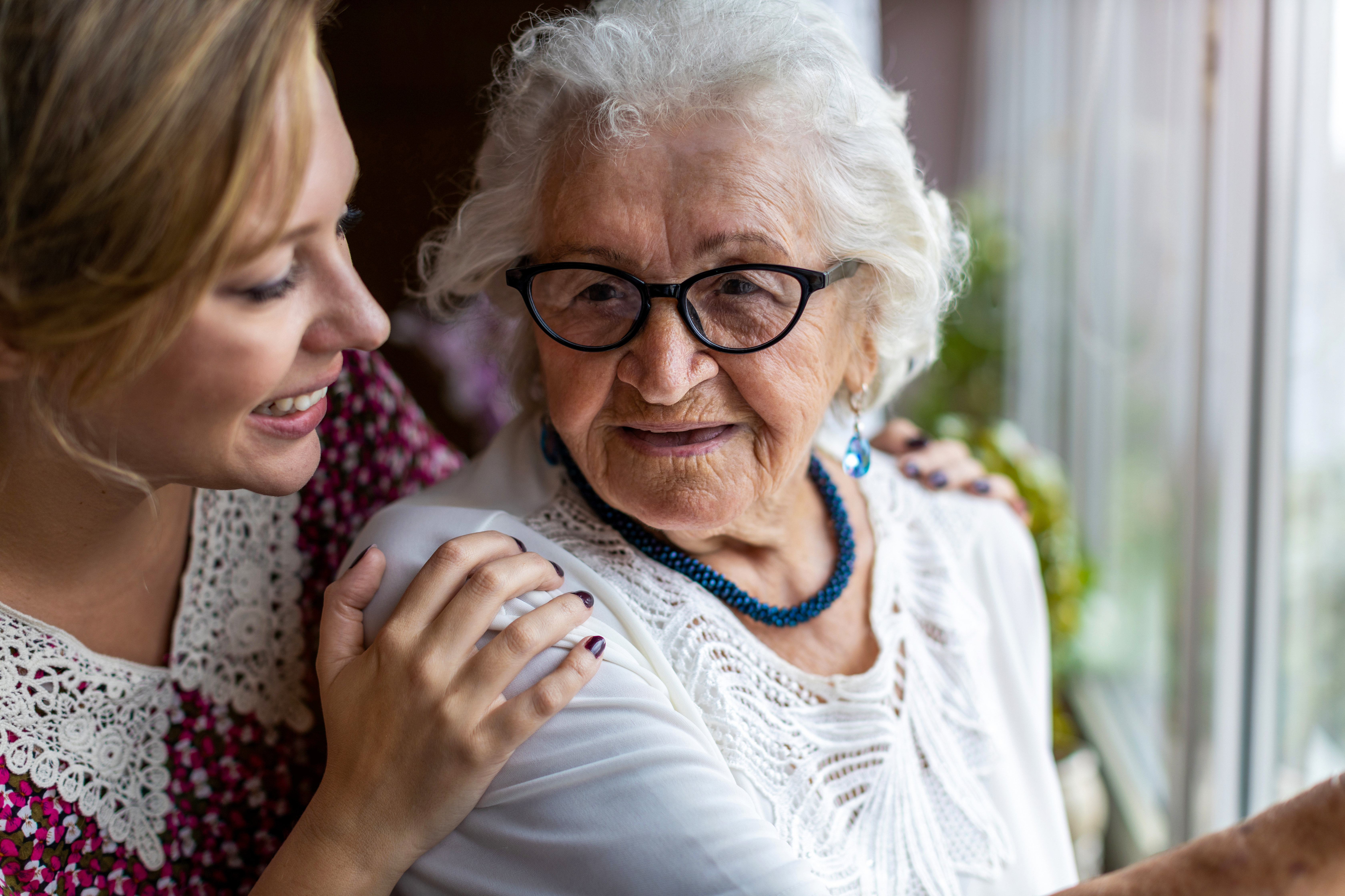 caregiver-and-older-adult-woman-looking-out-window