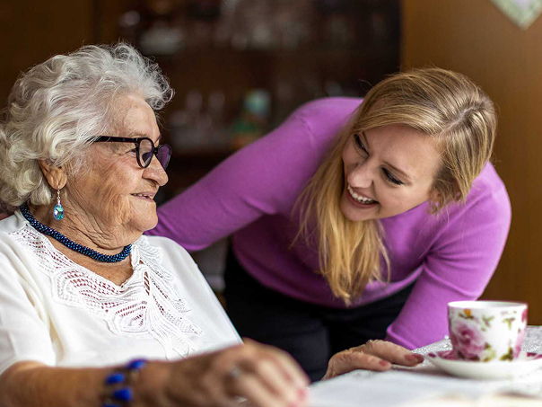 older-woman-reading-at-table-with-younger-woman 1