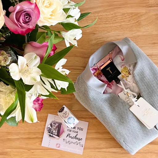 A bouquet, a folded shirt and a "Thank you for your purchase" card