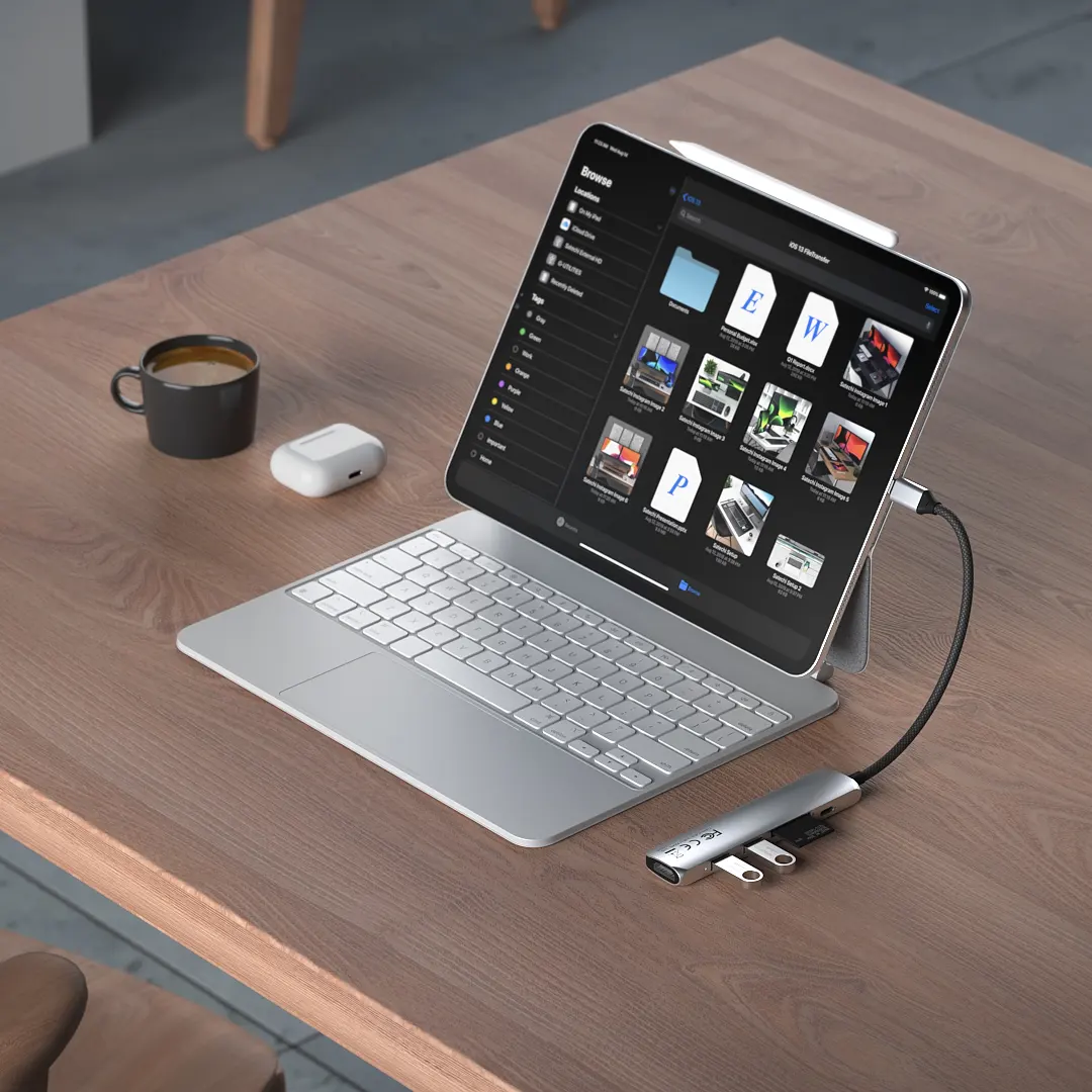 A Satechi 6-in-1 USB-C Slim Multiport Adapter connected and uploading images and files onto a MacBook.