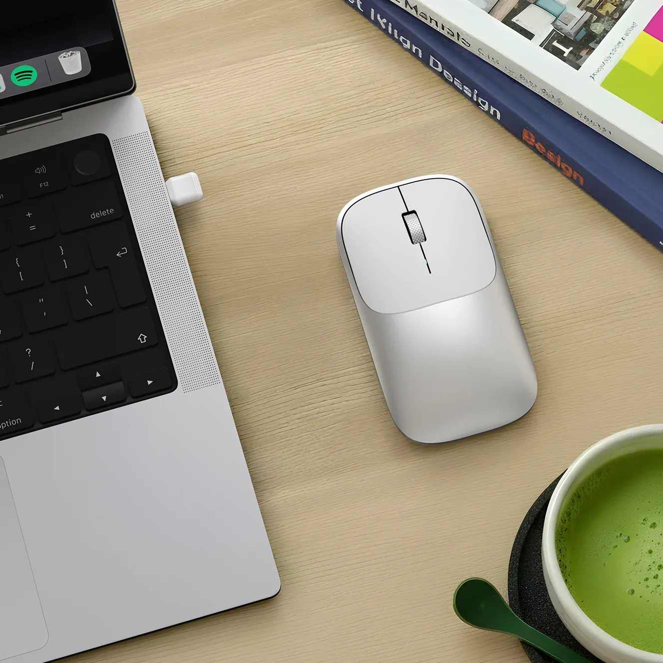A Slim EX Wireless Mouse on a desk alongside a Macbook.