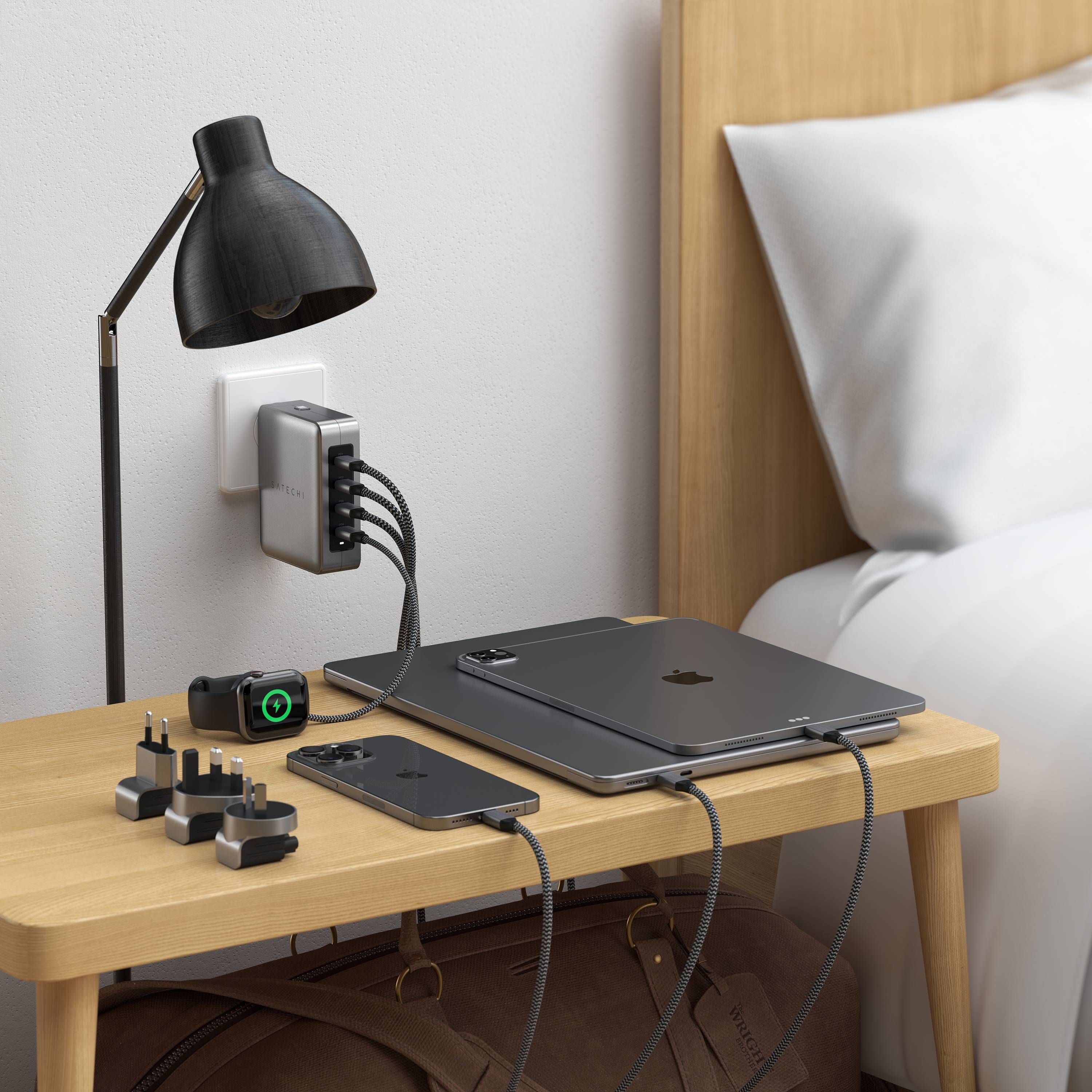 Satechi 145W USB-C 4-Port GaN Travel Charger charging an iPhone, Apple Watch, iPad, and MacBook simultaneously.