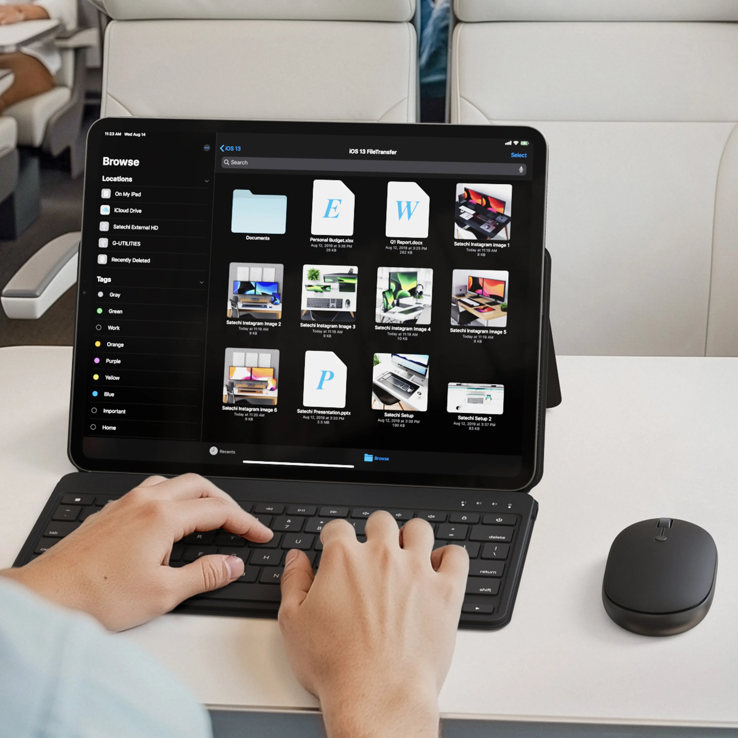 A person using the Satechi OntheGo™ Bluetooth Keyboard with Stand and Bluetooth Mouse to  work on their iPad on a train.