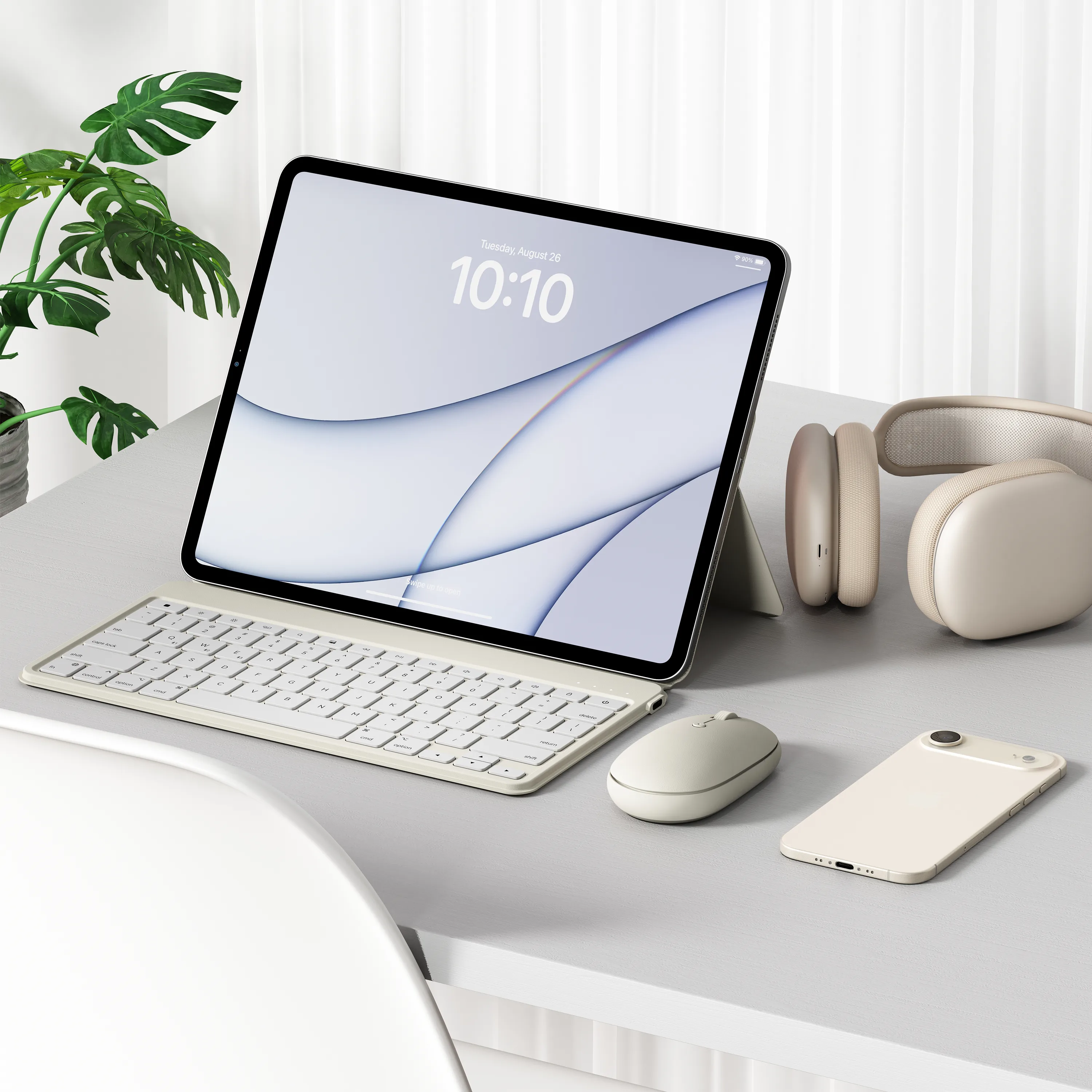 A OntheGo™ Bluetooth Keyboard with Stand in Sand, on a white desk next to an iPhone, OntheGo™ Bluetooth Wireless Mouse and headphones.