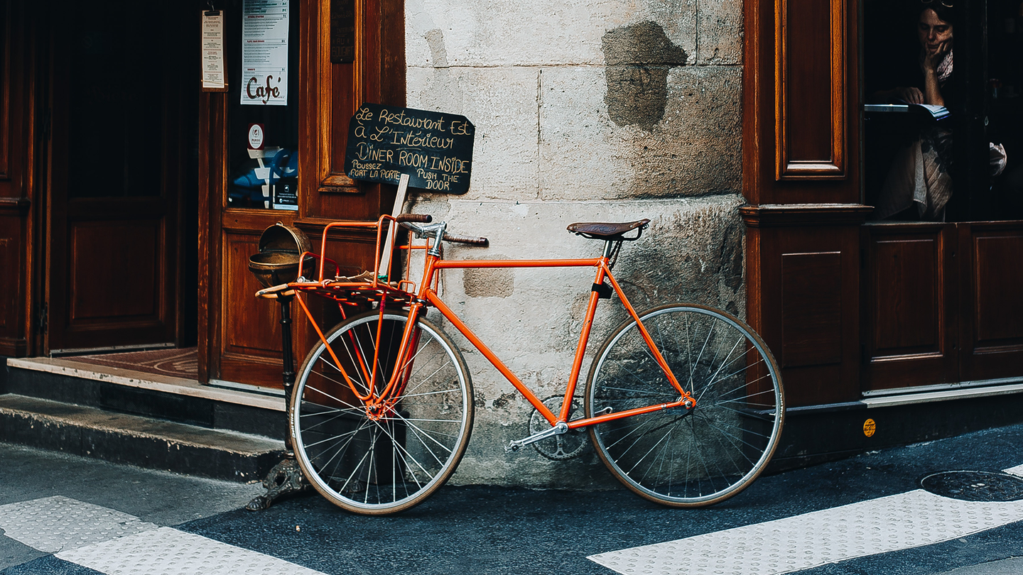 A bicycle leaning against a historical store in France