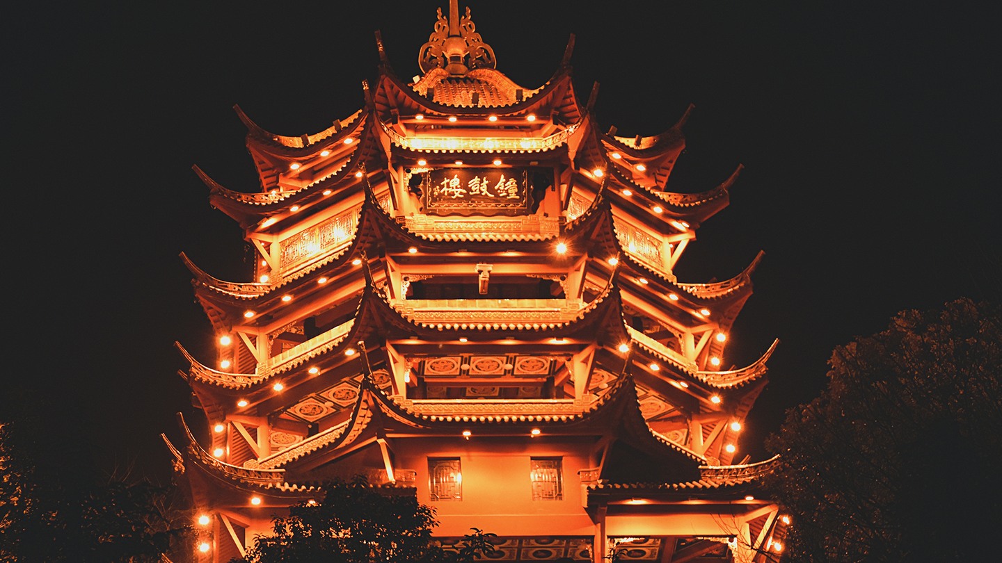 A multi-story pagoda-style building lit up at night