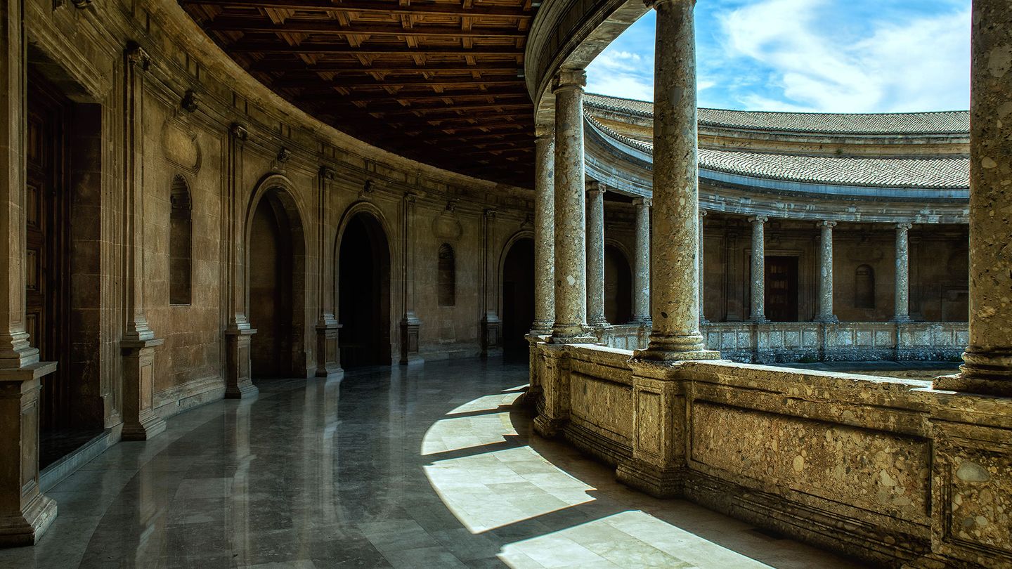 An arched portico with marble floors part of a historical building in Alhambra Spain