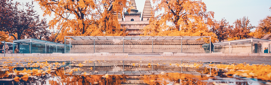 A historical Chinese temple (Wuta Temple) in the autumn above a reflective lake.