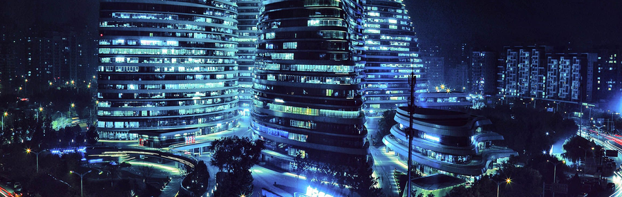 Tall modern buildings (Wangjing SOHO) lit up at night