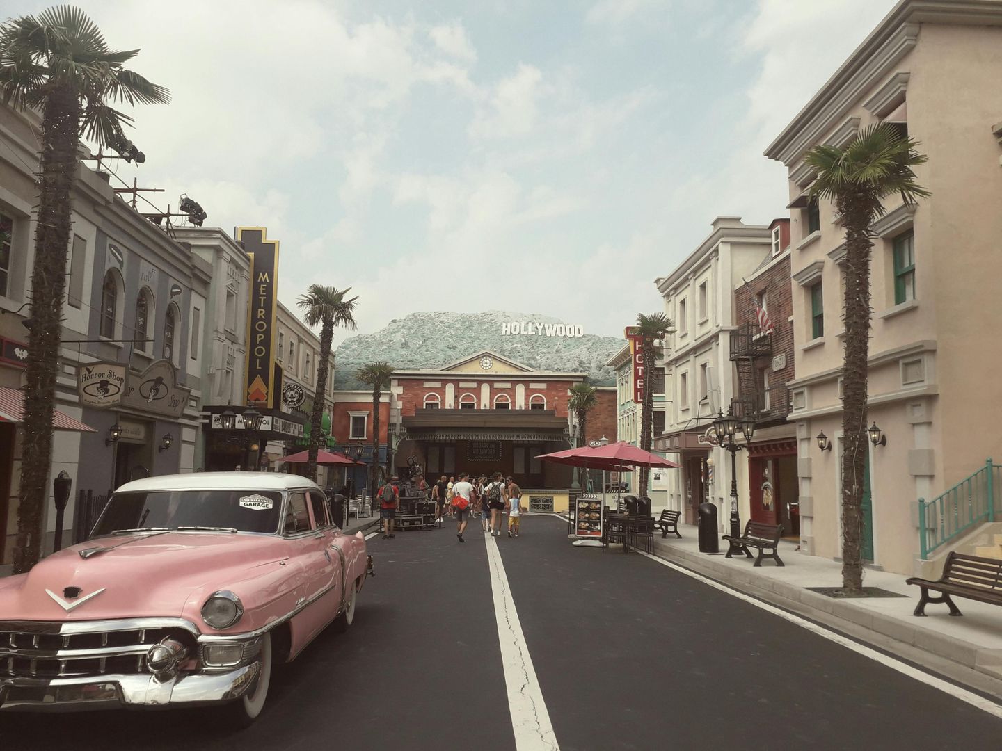 A street in Hollywood California with a pink old-fashioned Cadillac parked on the street