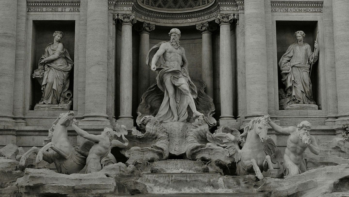 Detail of the Poseidon statue with water horses and creatures part of the Trevi fountain in Rome. A group of white marble statues