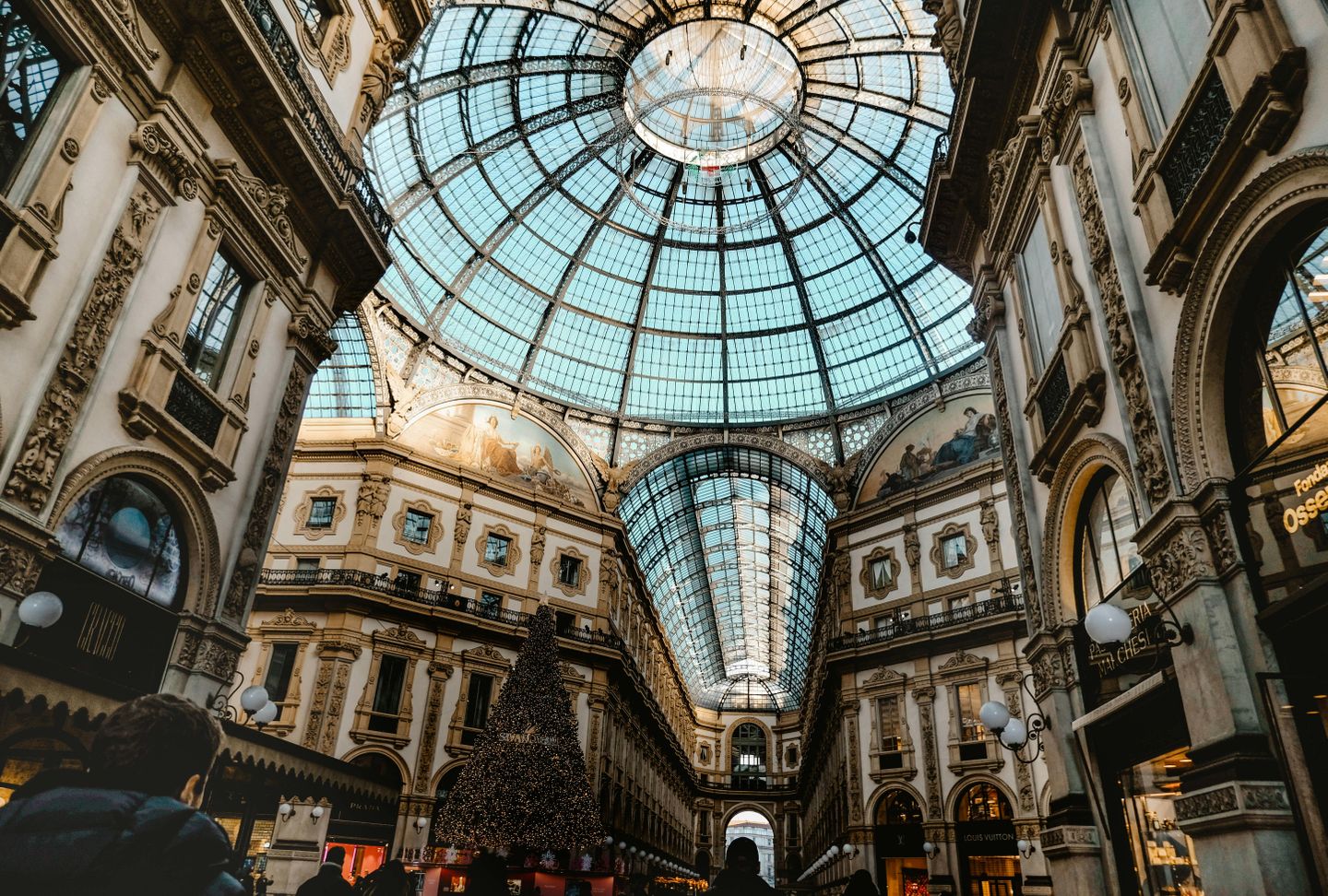 Glass gallery Vittorio Emanuele II in Milan, a shopping area bustling with people