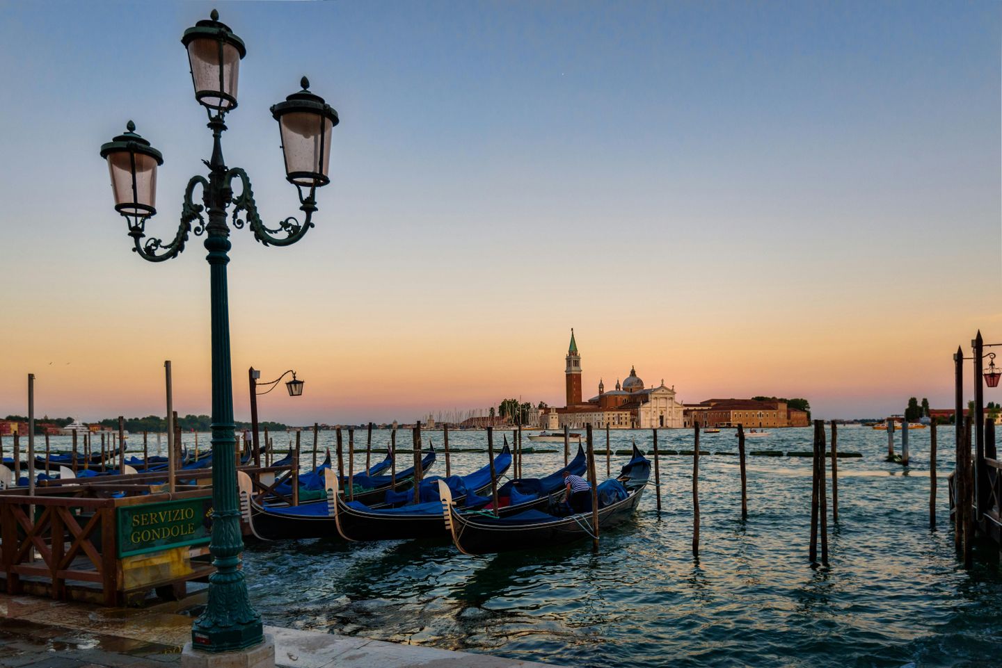 Blue Gondolas anchored in the Venetian lagoon at sunset