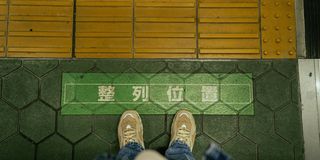 Colorful warnings printed on the floor of a Japanese subway platform