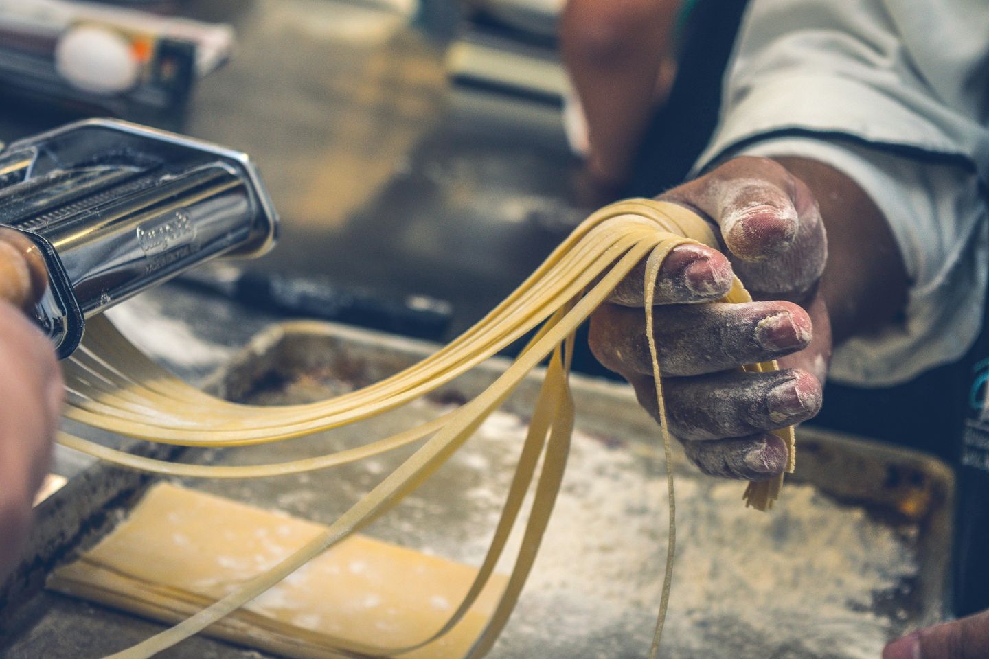 A man cutting fresh pasta in a cooking laboratory