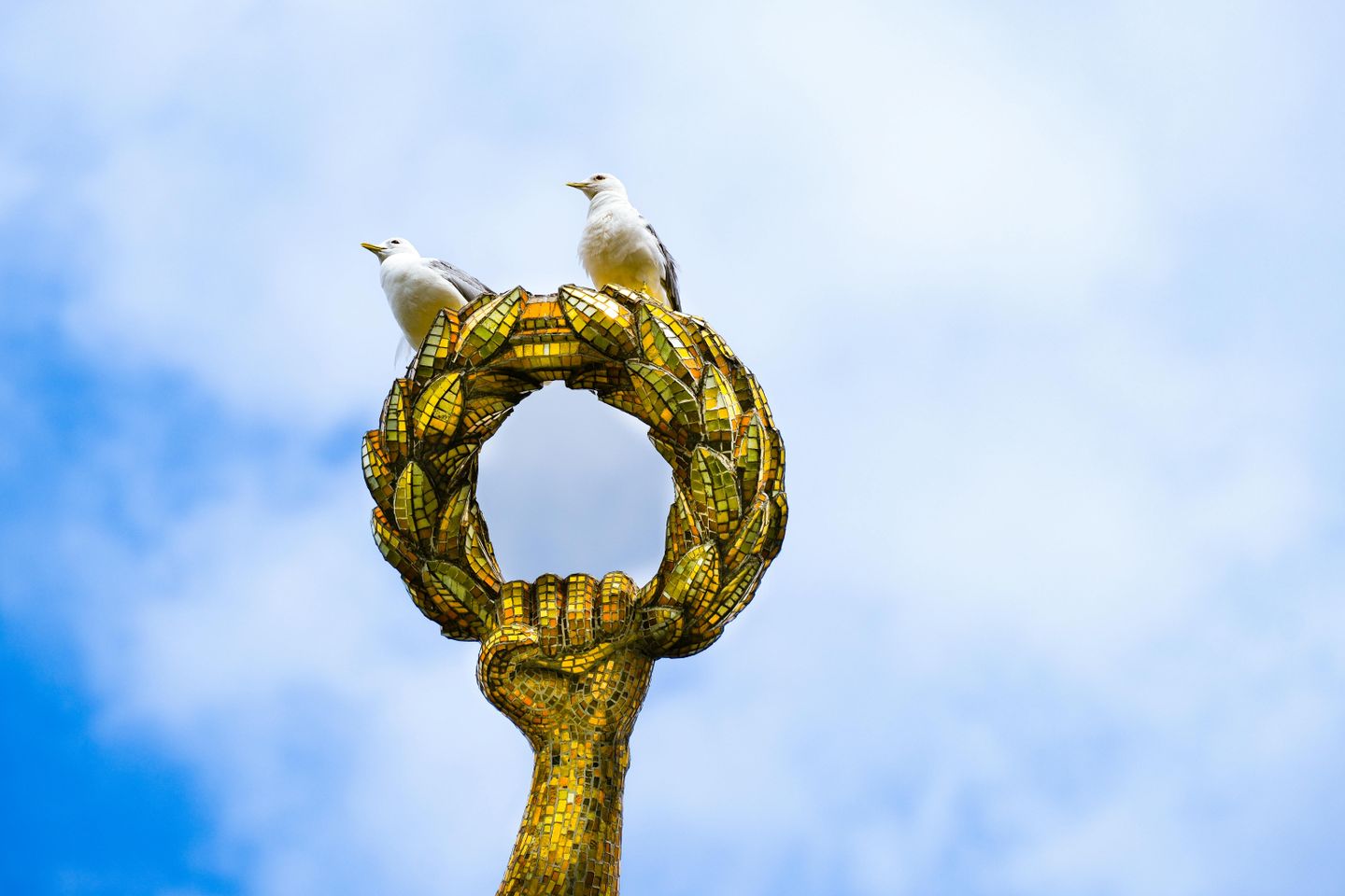 birds perch on a golden statue